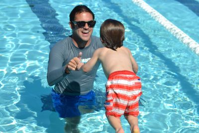 swim instructor with toddler in water